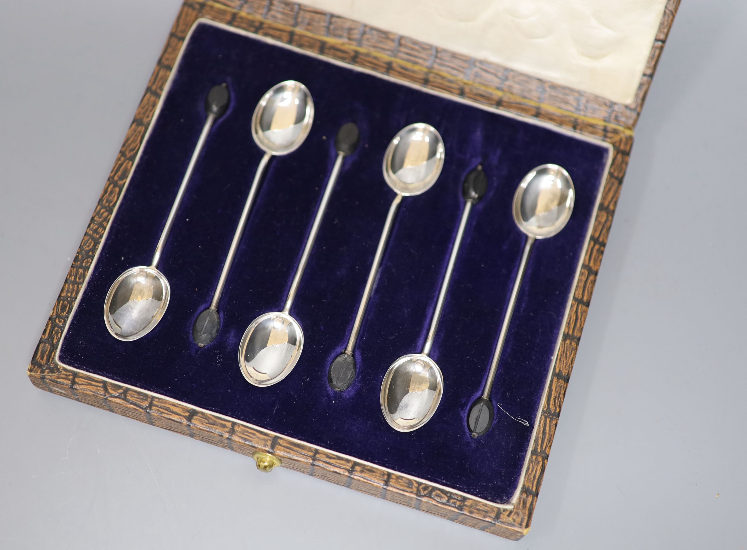 A cased set of six silver bean end coffee spoons, a cased silver spoon and pusher and a cased silver handled shoe horn and button hook.